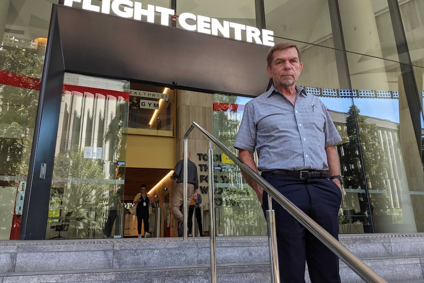 Graham Turner, Flight Centre CEO stands on the steps of one of his offices.