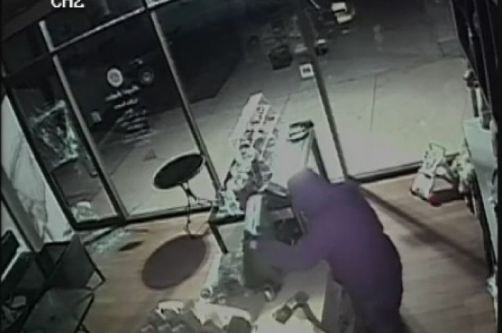 A burglar attempts to break open a cash register.