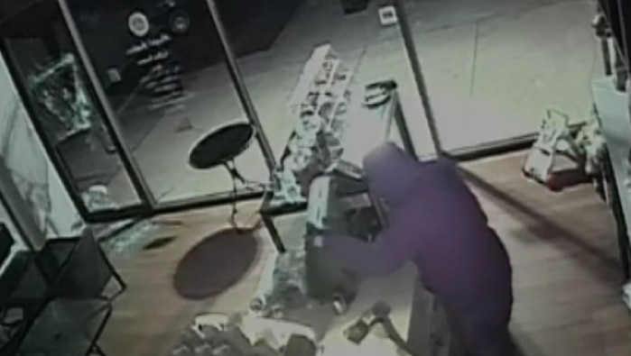 A burglar attempts to break open a cash register.