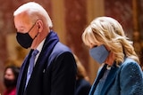 President Joe Biden and Dr Jill Biden, each wearing a face mask and praying.
