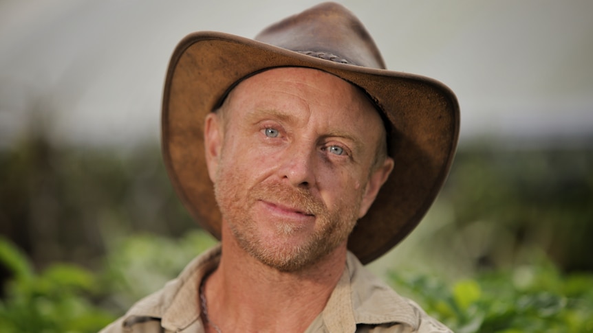 A man wearing a brown hat and brown shirt.