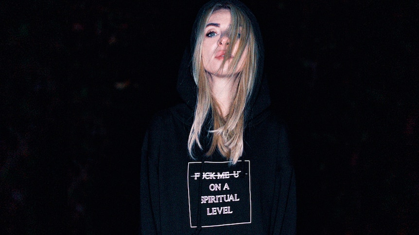 A shot of Alison Wonderland wearing a "f--k me up on a spiritual level" hoodie