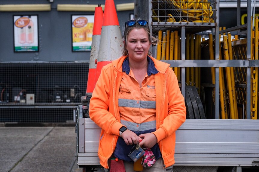a woman in a high vis jacket standing in front of a ute