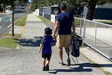A man takes a little boy to school.