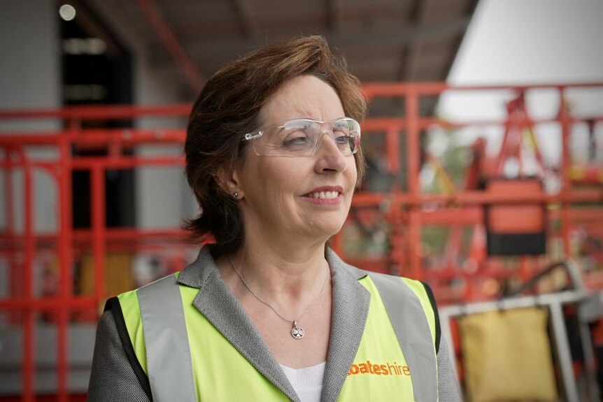 A woman wearing glasses and a high-vis vest.