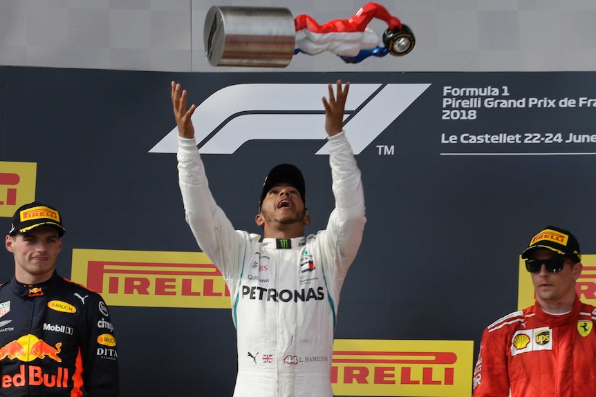Lewis Hamilton of Britain throws the trophy in the air