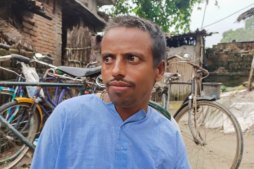An Indian man looks off in a village