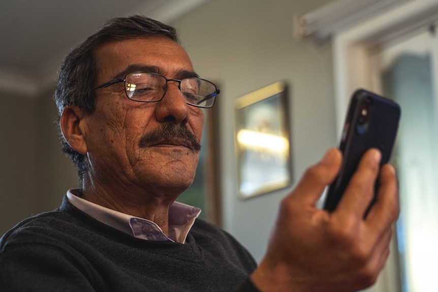 a man watching  the screen of a mobile phone