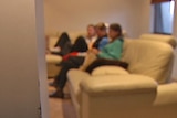 Video still: Blurred image of young people sitting on a lounge chair  - generic