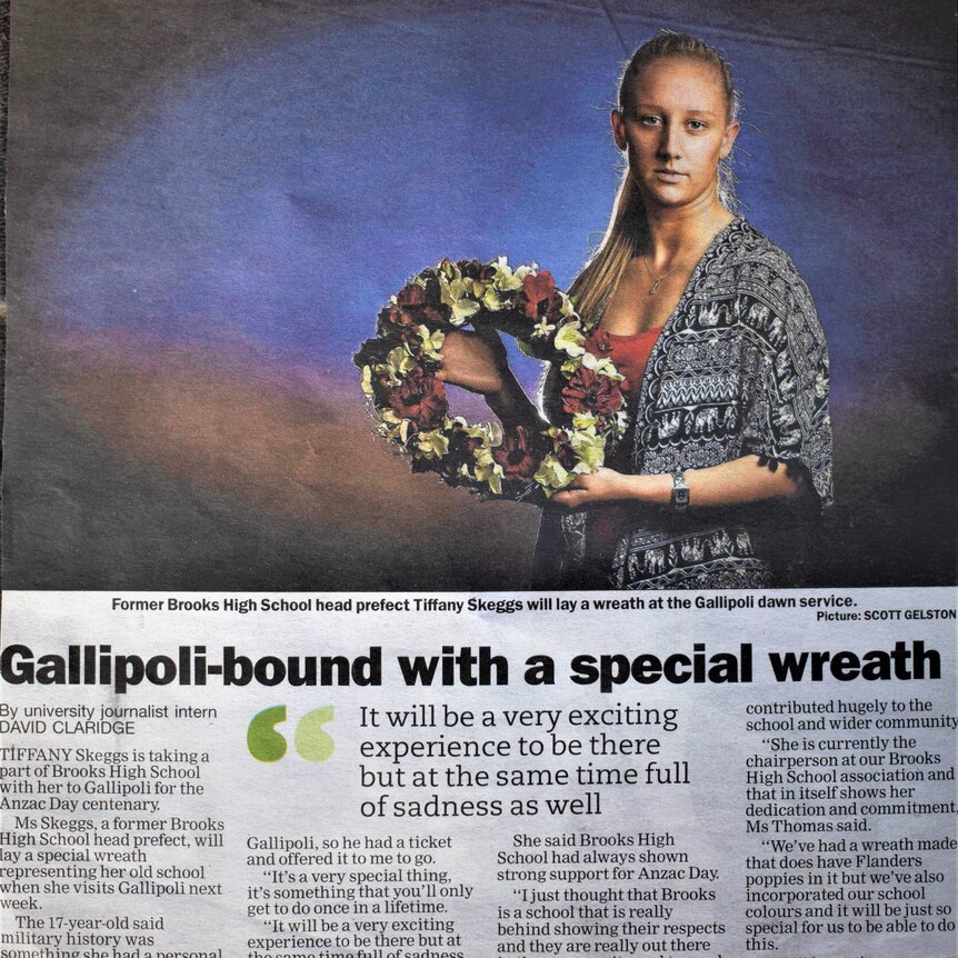 Newspaper clipping with a photo of Tiffany Skeggs holding a wreath. 