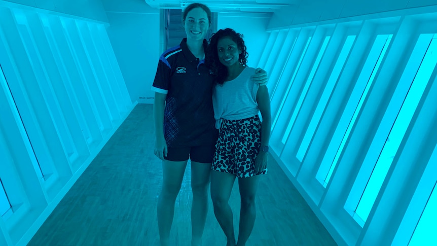 Two women stand in a underwater observatory.