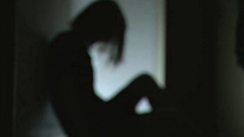 A silhouette of a woman sitting on the ground