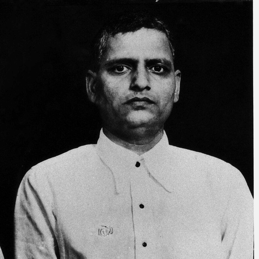black and white mug shots of Nathuram Godse in button up shirt, one side profile, one front on