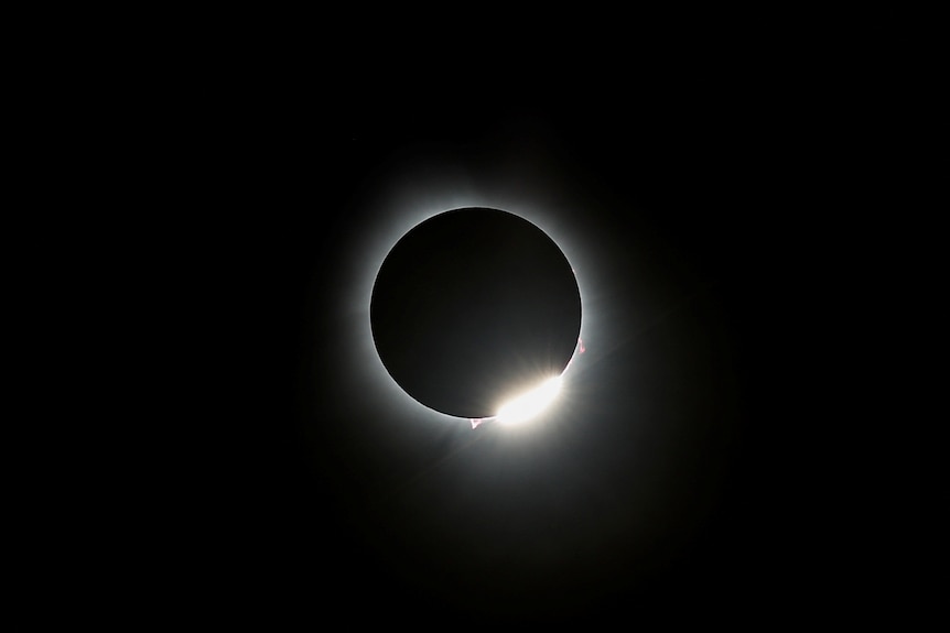 A solar eclipse with a small amount of sun showing. 