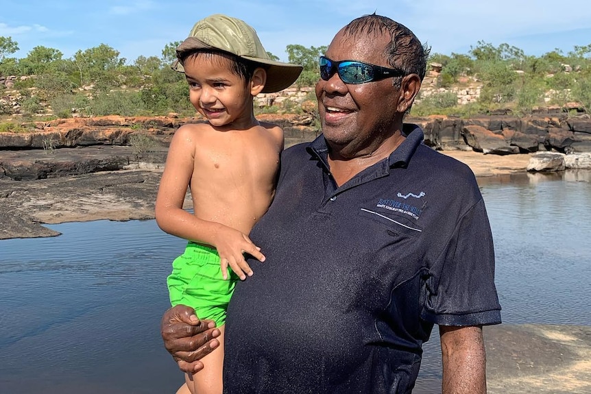 A man holding a little boy near King George Falls.