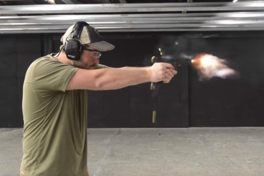 A screenshot from a YouTube video showing a man firing a Glock handgun at a firing range.
