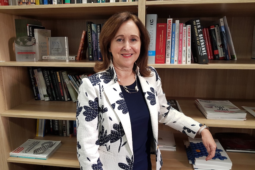 Debby Blakey stands in front of a bookshelf in the library at HESTA's Melbourne office in May 2021. 