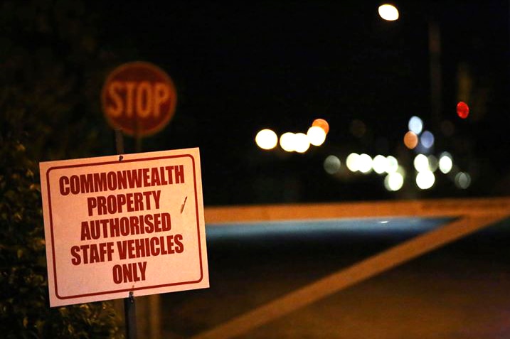 A sign at the entrance to Christmas Island's detention centre at night saying only authorised staff vehicles are allowed.