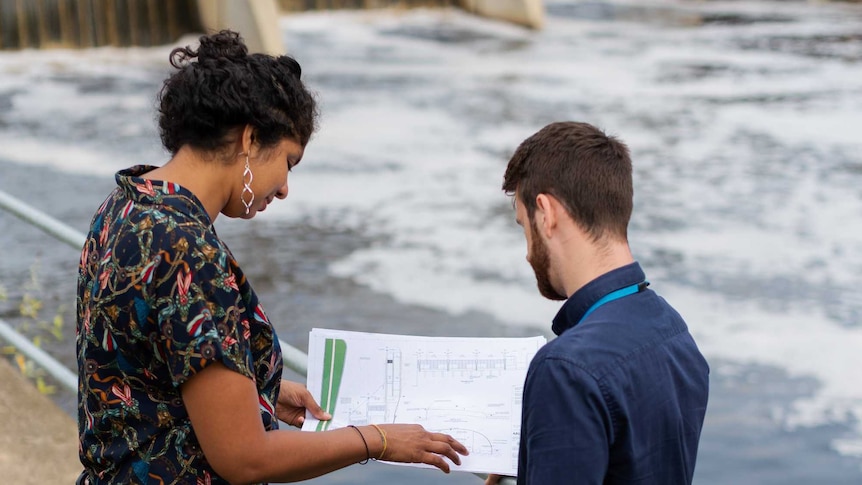 Male and female engineer looking at paperwork