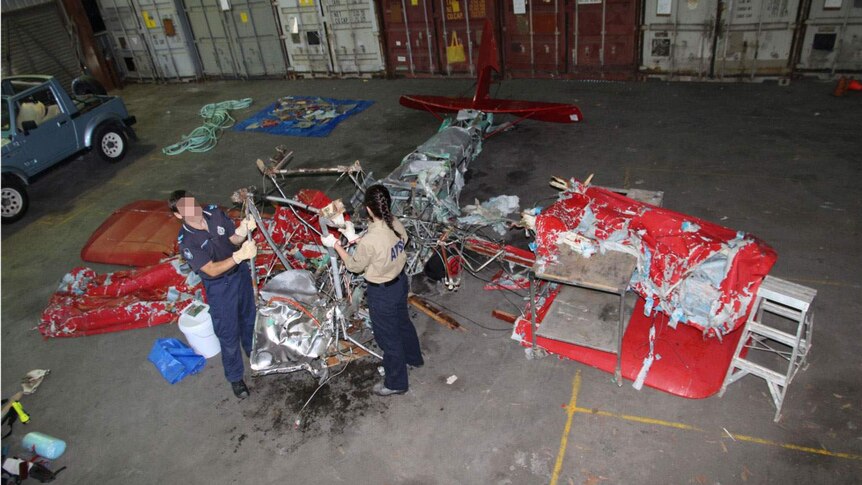 ATSB investigators examine reassembled wreckage from the Tiger Moth.
