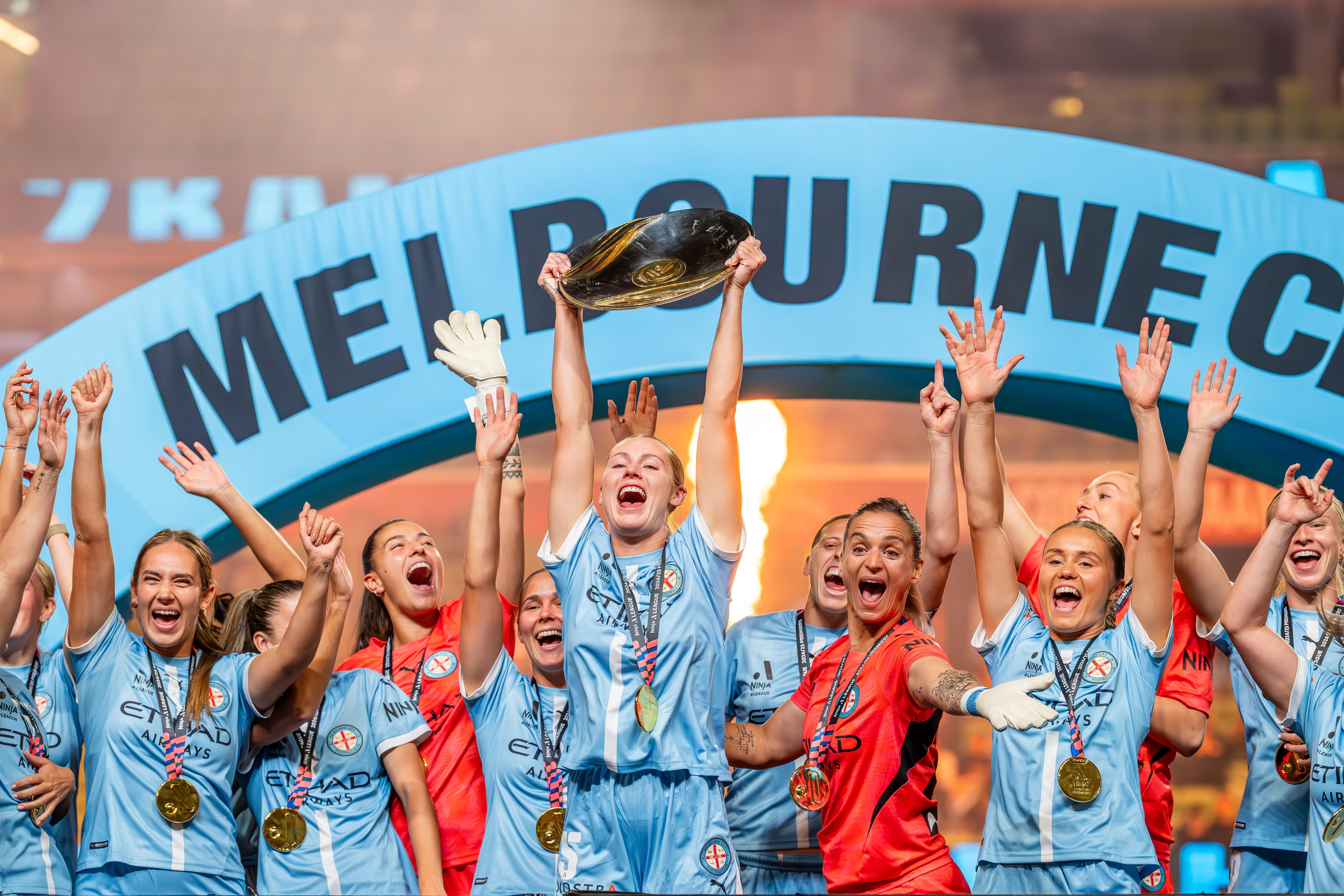 Jogadores de futebol com uniformes azuis comemoram a vitória.
