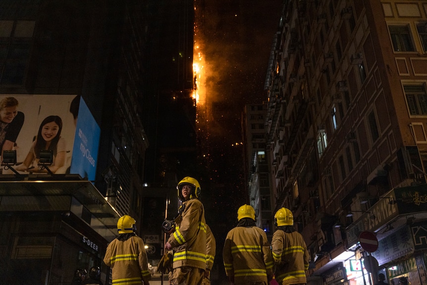 One firefighter looks behind as Firefighters battle a fire at a construction site in Hong Kong.