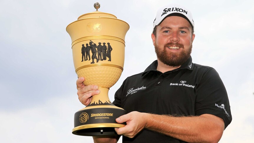 Ireland's Shane Lowry holds the Gary Player Cup after winning the WGC Invitational tournament.