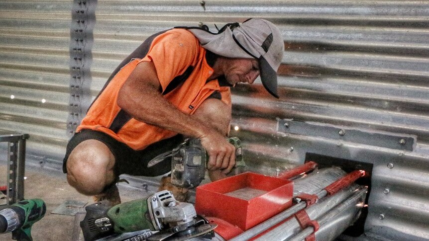 A tradesman welds an unload auger inside one of the new grain silos.