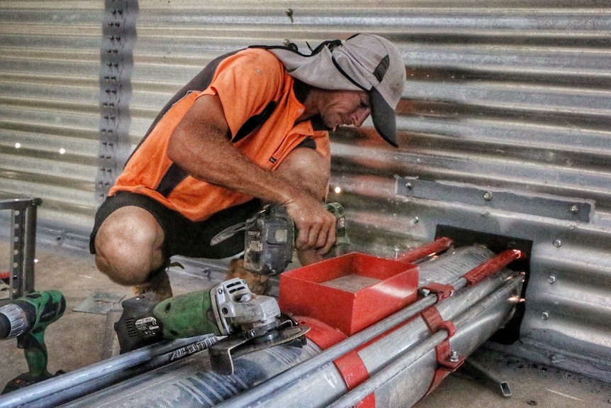 A tradesman welds an unload auger inside one of the new grain silos.