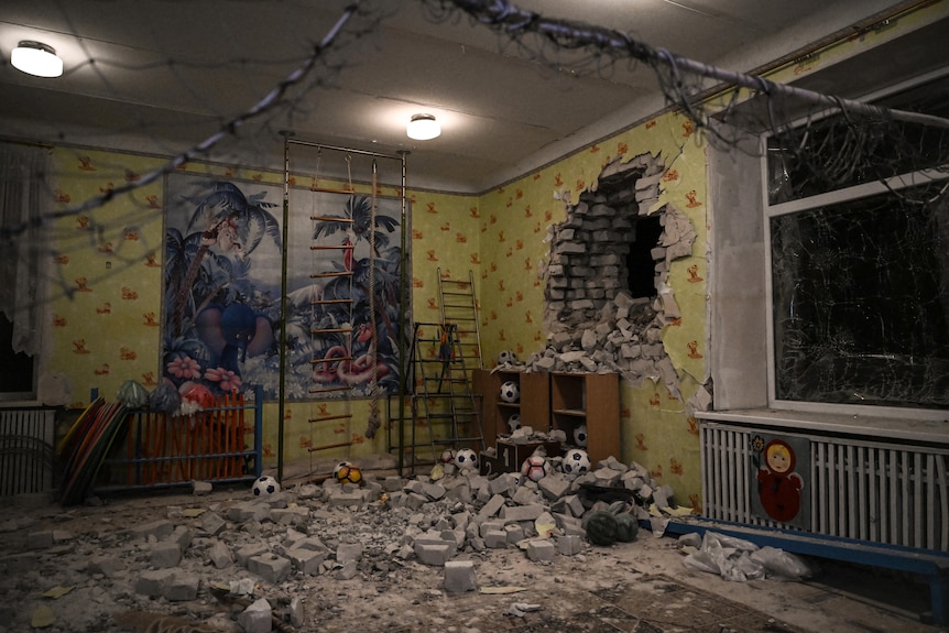  A damaged wall and a room full of debris and toys is seen after the reported shelling of a kindergarten.