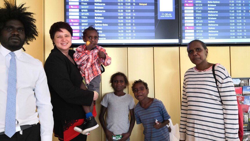 A group of adults and children at an airport.