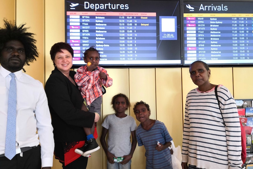 A group of adults and children at an airport.