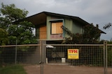 A green house with temporary fencing around it. 