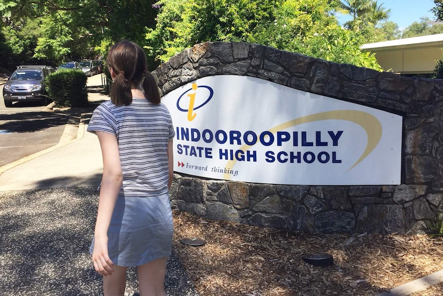 A student not wearing a school uniform walks into Indooroopilly State High School.