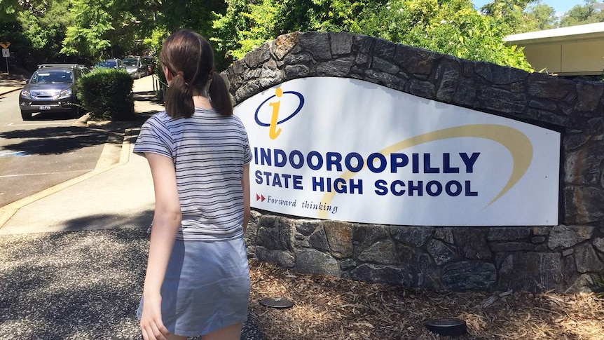 A student not wearing a school uniform walks into Indooroopilly State High School.