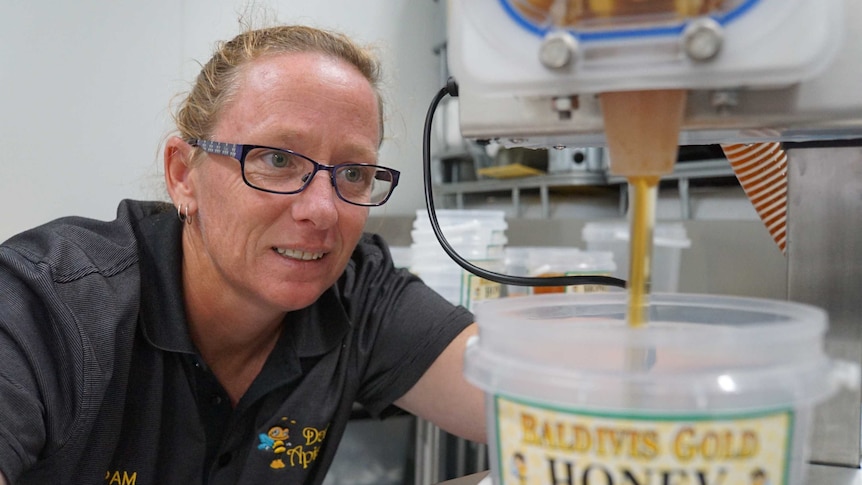 A woman pouring honey in a factory.