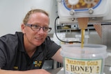 A woman pouring honey in a factory.