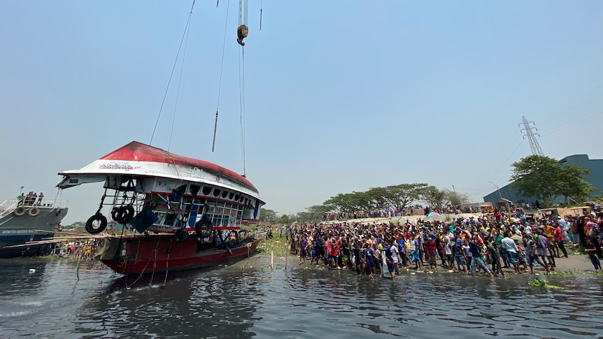 A capsized ferry is lifted from a river in Bangladesh