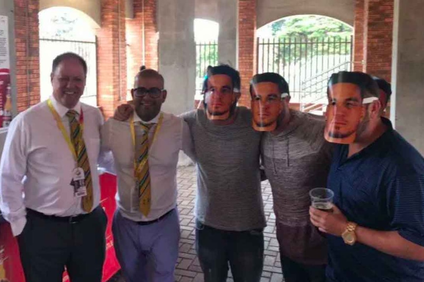 Cricket South Africa officials Clive Eksteen and Altaaf Kazi pose with spectators wearing Sonny Bill Williams masks.