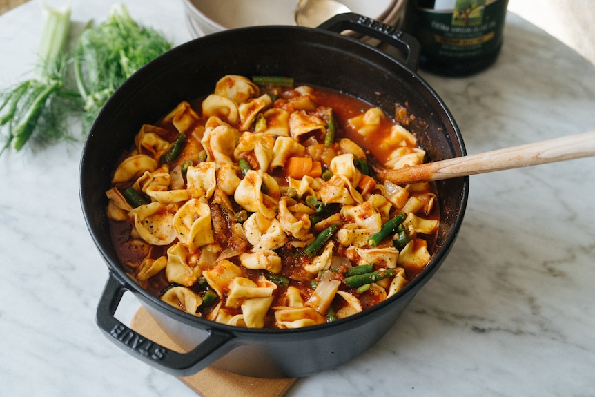 A pot of cooked tortellini soup.