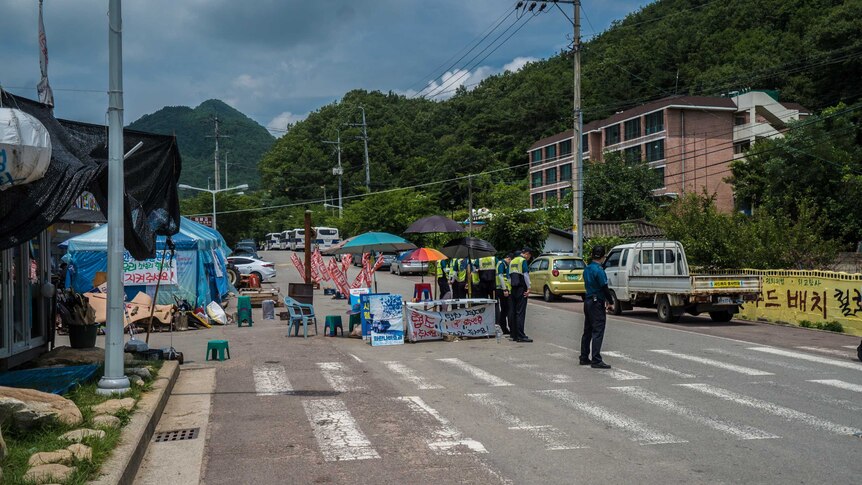 Police and security stand in a line on the road into Seongju.