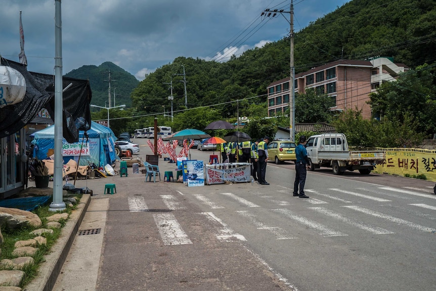 Police and security stand in a line on the road into Seongju.