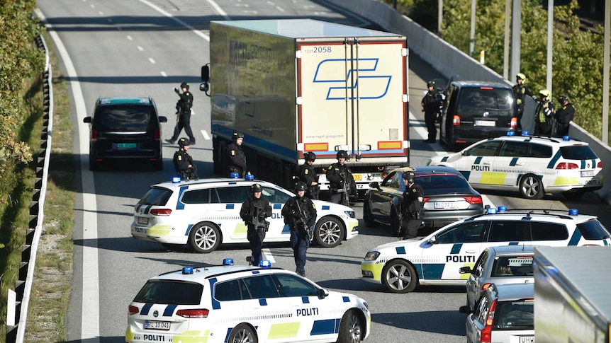 Danish police vehicles line up across a bridge blocking the road