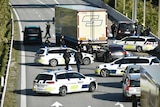 Danish police vehicles line up across a bridge blocking the road
