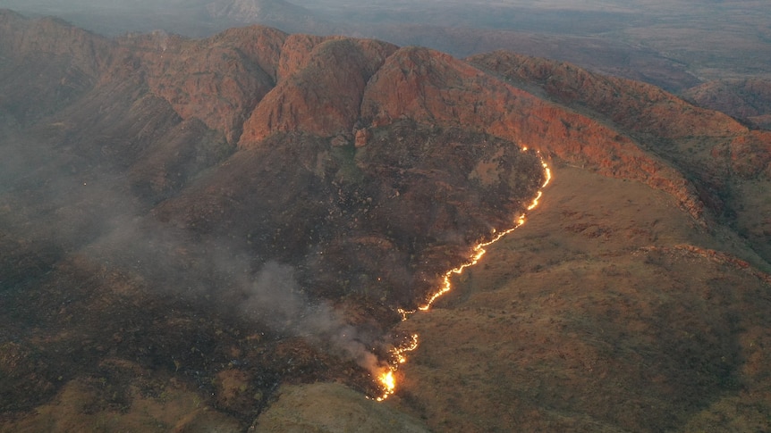 an aerial photo of a fire burning on a hill. 
