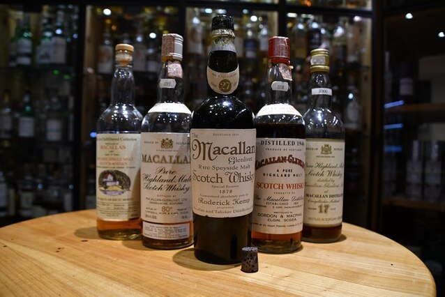 The fake Macallan 1878 "single malt" scotch sits on a table with other bottles.