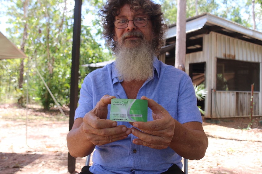 Andrew Walton holds a Basics Card out in front of him