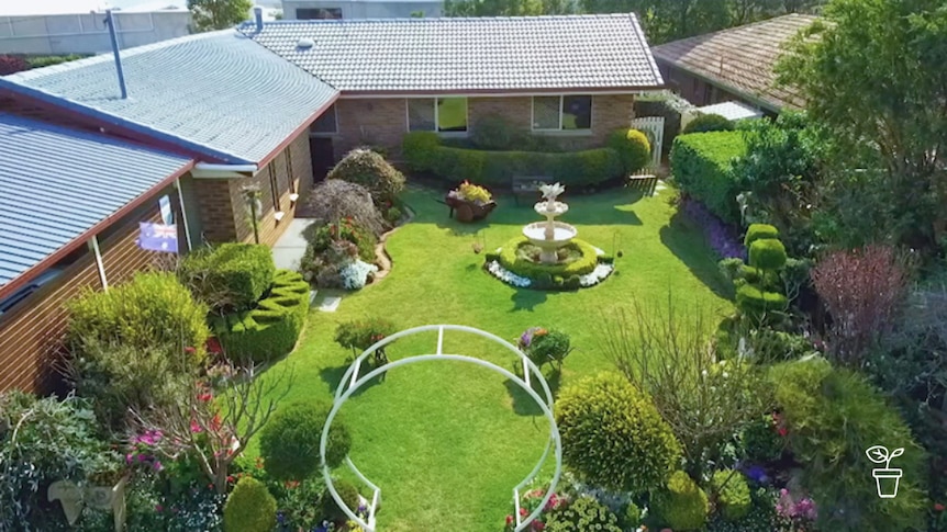 Bird-eye view of suburban home garden with arch at entrance