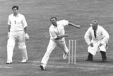 Richie Benaud is watched carefully by the umpire as he bowls in the England v Australia test match in 1961.