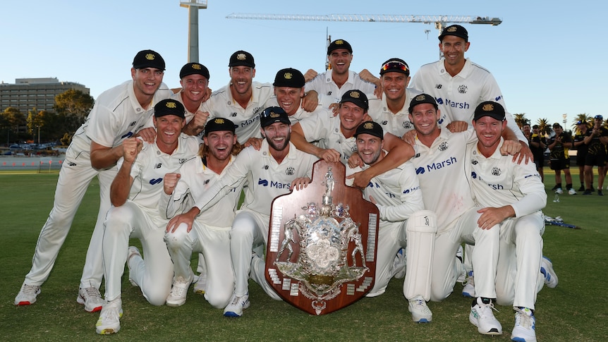 Western Australia cricketers pose for a photo with the Sheffield Shield trophy after the 2024 final.